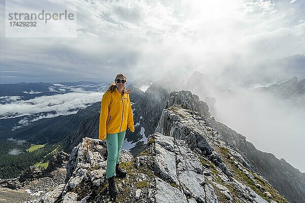Wanderin auf einem Gipfel  Westliche Törlspitze  Berge bei dramatischen Wolken  Wettersteingebirge  Garmisch-Partenkirchen  Bayern  Deutschland  Europa