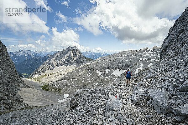 Wanderin durchquert ein Geröllfeld  Wanderung zur Patenkirchner Dreitorspitze  Wettersteingebirge  Garmisch-Partenkirchen  Bayern  Deutschland  Europa