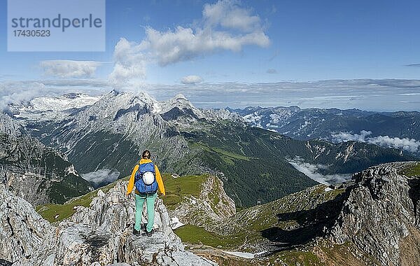 Wanderin auf einem Gipfel  Westliche Törlspitze  Berge bei dramatischen Wolken  hinten Zugspitze  Wettersteingebirge  Garmisch-Partenkirchen  Bayern  Deutschland  Europa