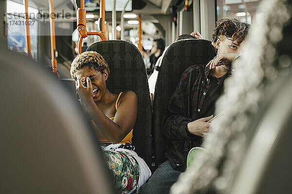 Fröhliche multirassische Freunde  die sich im Bus vergnügen