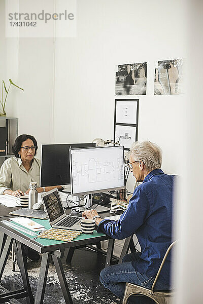 Weibliche und männliche Kollegen arbeiten am Computer im Büro