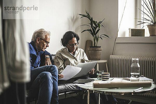 Ältere männliche und weibliche Eigentümer beim Brainstorming mit Laptop in einem Workshop