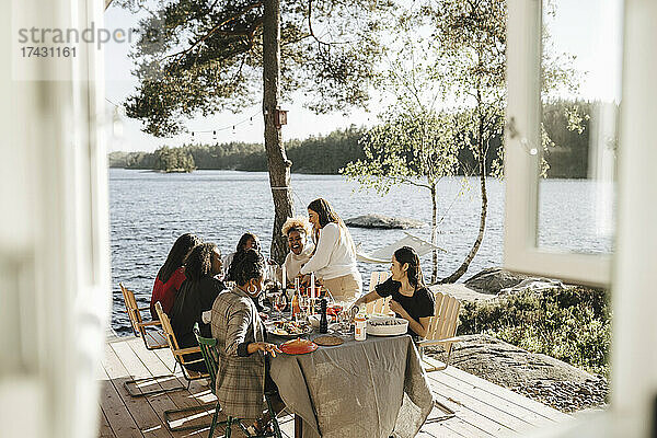 Fröhliche Freundinnen genießen das Essen auf einer Dinnerparty an einem sonnigen Tag