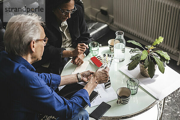 Hohe Winkel Ansicht der männlichen und weiblichen Eigentümer diskutieren am Tisch im Büro