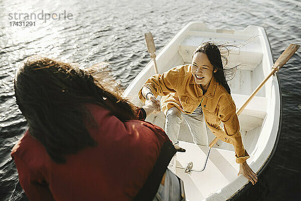 Hohe Winkel Ansicht der Frau hilft weiblichen Freund für den Ausstieg aus dem Boot