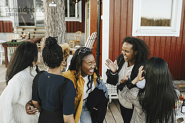 Junge weibliche Freunde lachen auf einer Party im Hinterhof