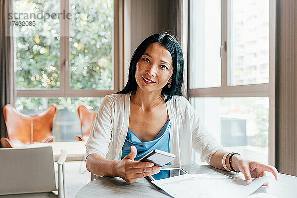 Italien  Porträt einer lächelnden Geschäftsfrau am Tisch im Kreativstudio
