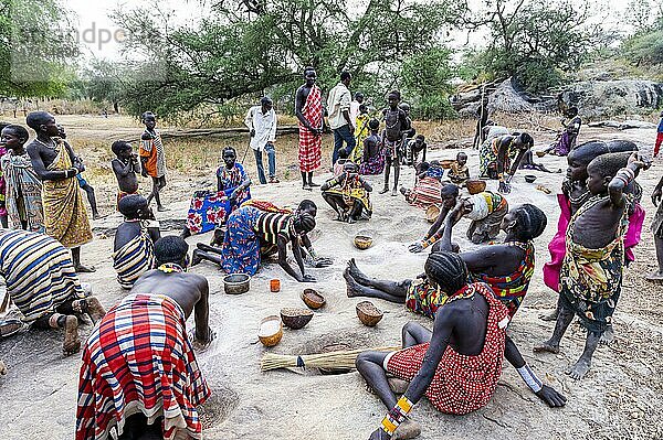 Junge Mädchen mahlen Sorghum auf einem Felsen  Stamm der Laarim  Boya Hills  Ost-Äquatoria  Südsudan  Afrika