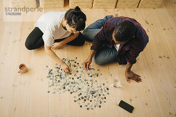 Hohe Winkel Ansicht des Paares spielen Puzzle im Wohnzimmer zu Hause
