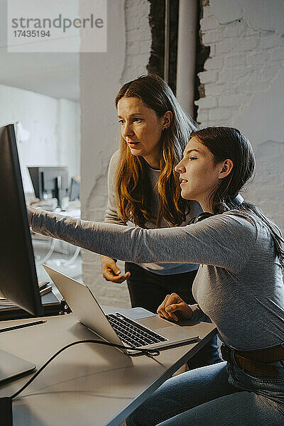 Weibliche Hacker kommunizieren bei der Arbeit am Computer im Büro