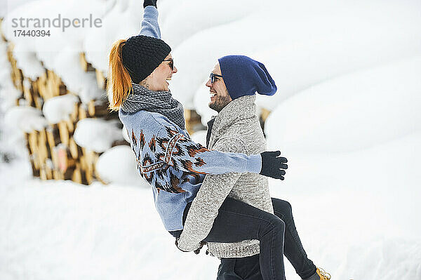 Glückliches Paar genießt den Schnee im Winter