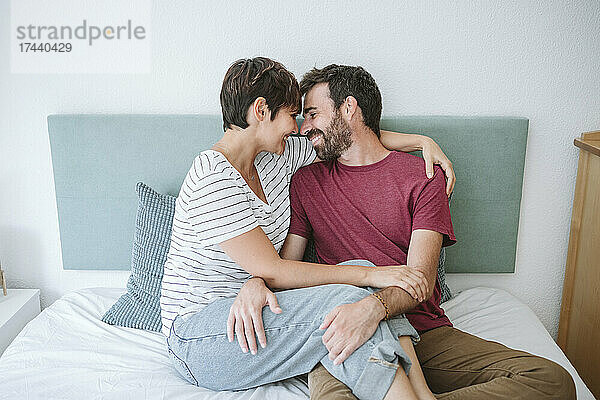 Romantisches Paar sitzt zu Hause zusammen im Bett
