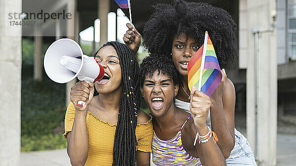 Lesbische Frauen mit Stolzflagge schreien während des Protests