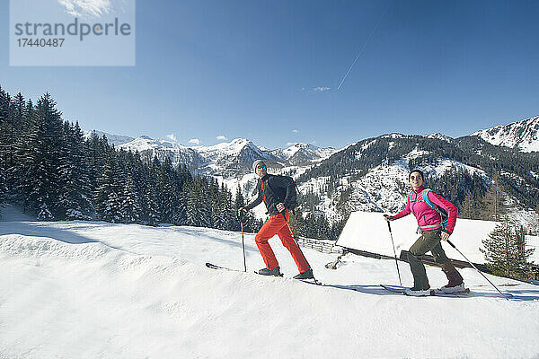 Junger Mann und Frau Skifahren auf Schnee