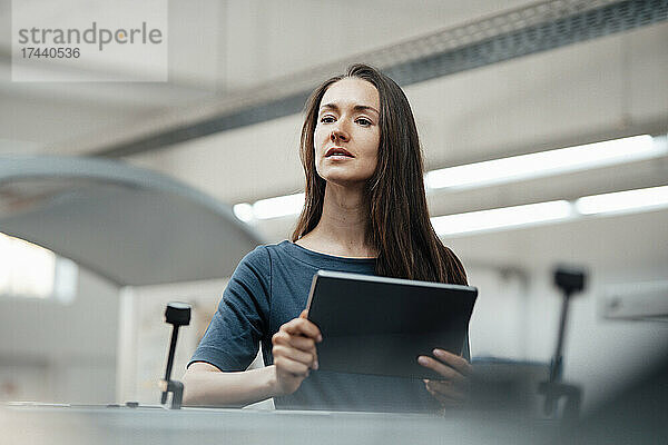 Berufstätige Frau mit digitalem Tablet-Prüfgerät in der Industrie