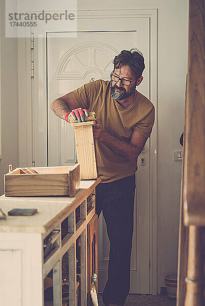 Handwerker schleift Holz zu Hause