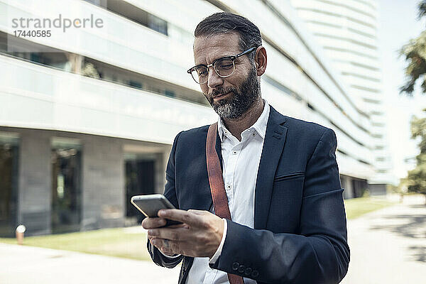 Geschäftsmann mit Brille nutzt Smartphone