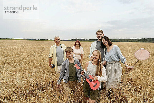 Glückliche Familie  die auf Weizenfeld spaziert