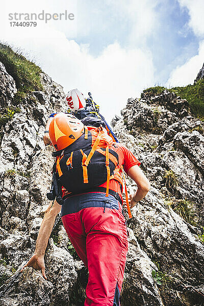 Männliche Wanderer klettern auf felsigen Berg
