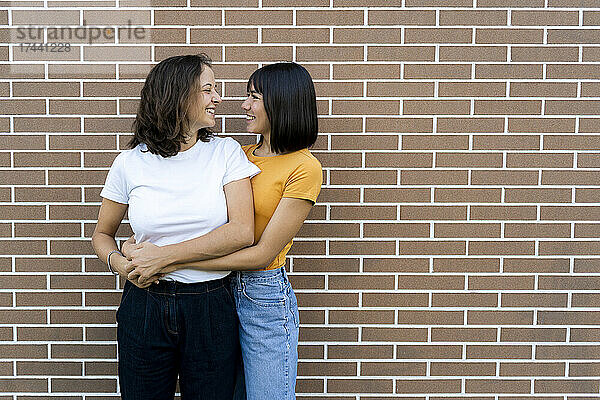 Lesbisches Paar schaut sich vor der Wand an