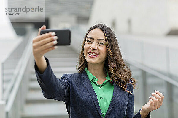 Lächelnde Geschäftsfrau macht Selfie per Smartphone