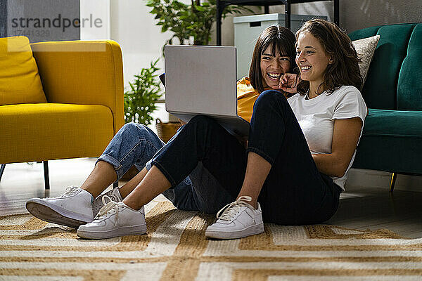 Glückliche Frauen benutzen Laptop im Wohnzimmer