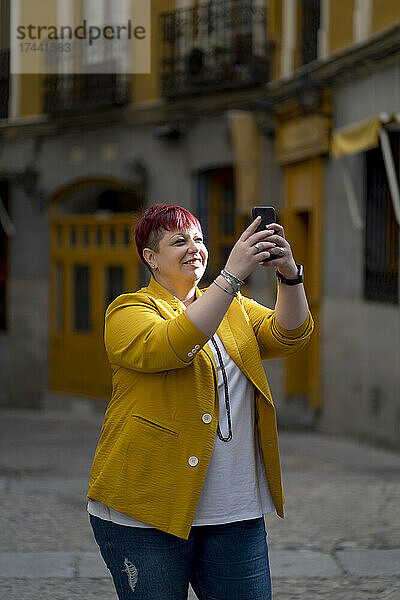 Übergewichtige Frau macht Selfie mit Handy auf Fußweg