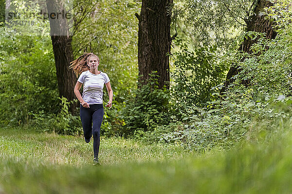 Junge Sportlerin läuft im Wald