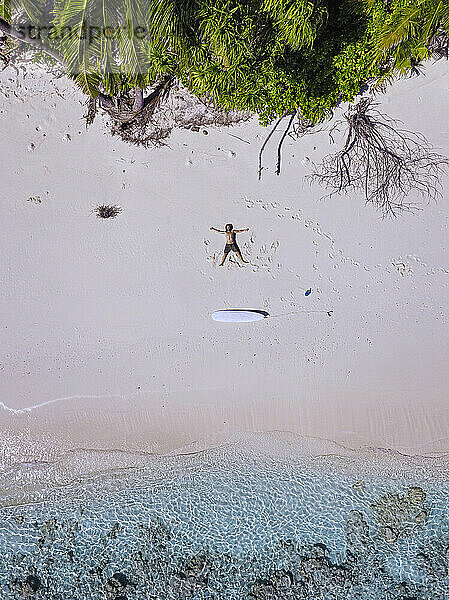 Man with arms outstretched relaxing on beach