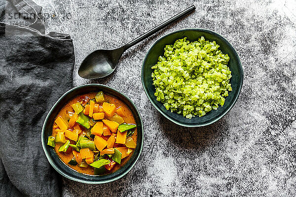 Studio shot of bowl of ready-to-eat low carb curry and chopped broccoli