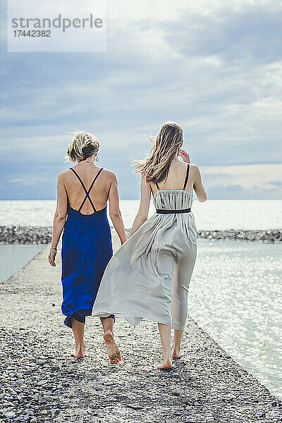 Teenager-Mädchen und Frau gehen gemeinsam am Pier spazieren