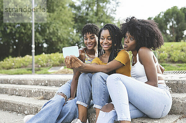 Glückliche Freundinnen machen Selfie mit dem Smartphone im Park