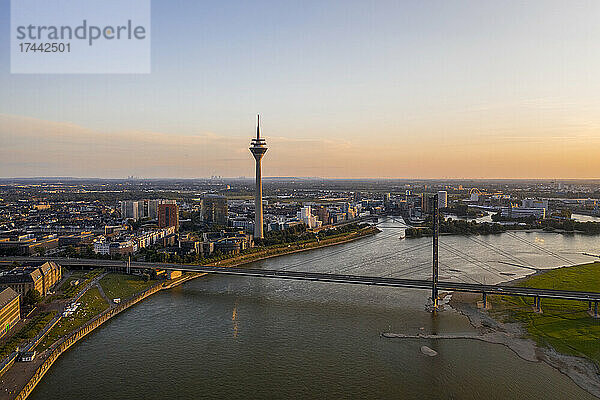 Deutschland  Nordrhein-Westfalen  Düsseldorf  Luftaufnahme der Rheinkniebrücke in der Abenddämmerung mit Rheinturm im Hintergrund