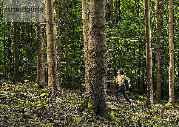 Junge Sportlerin läuft im Wald