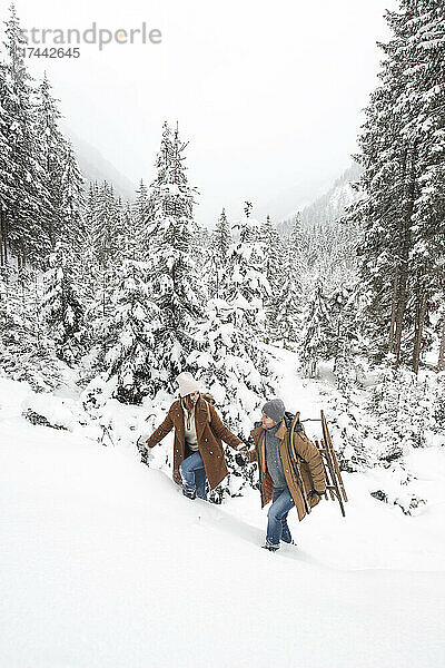 Junges Paar läuft im Winter auf Schnee