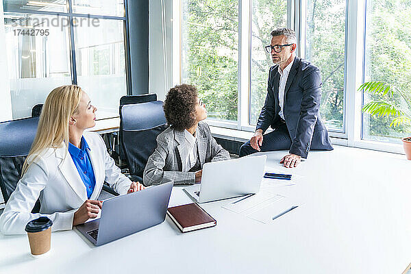 Männliche und weibliche Geschäftsleute diskutieren bei einem Treffen im Büro