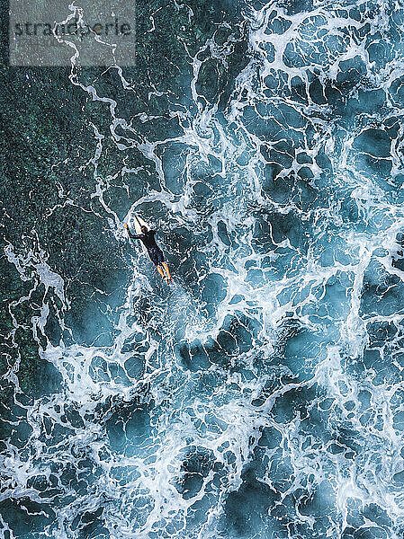 Mann liegt auf einem Surfbrett beim Schwimmen im Meer auf der Insel Huraa  Malediven