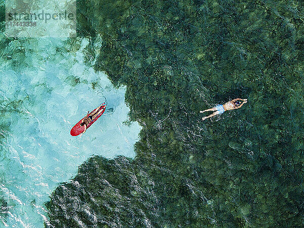Männliche und weibliche Touristen schwimmen im offenen Wasser auf der Insel Huraa  Malediven