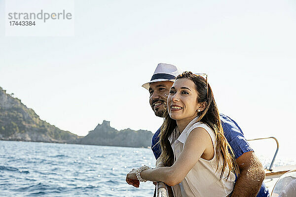 Glückliches Paar  das an einem sonnigen Tag zusammen im Motorboot steht