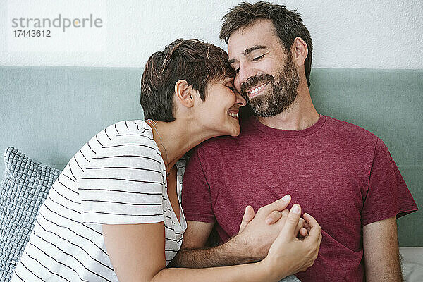 Lächelnder Mann und Frau im Bett zu Hause