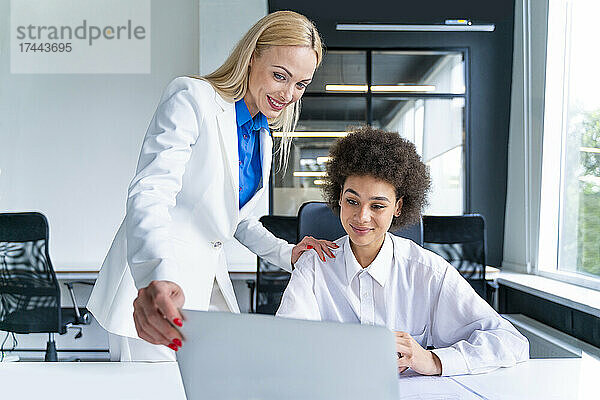 Weibliche Geschäftsleute teilen sich Laptop am Arbeitsplatz