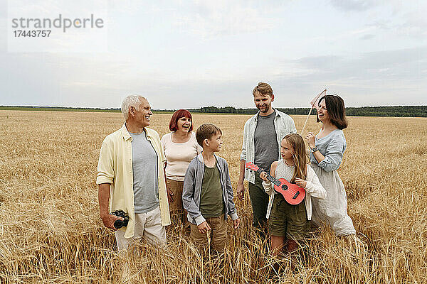 Glückliche Familie  die zusammen im Weizenfeld steht