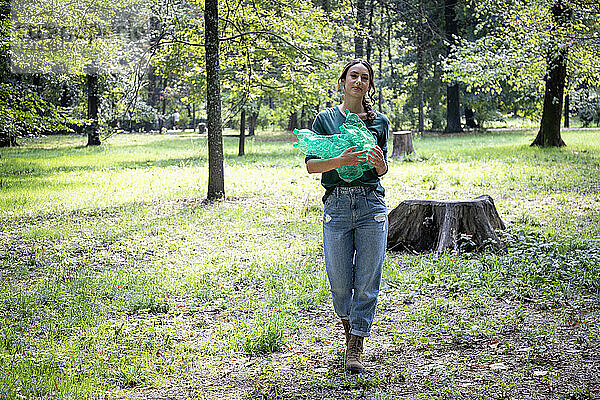 Frau sammelt Plastikflaschen im Park
