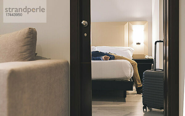 Geschäftsmann entspannt sich im Bett im Hotelzimmer