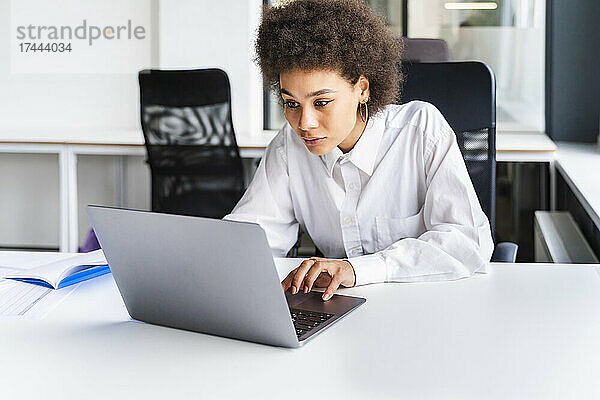 Junge Berufstätige benutzt Laptop am Schreibtisch im Büro