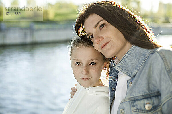 Mutter stützt sich am Ufer auf ihre Tochter