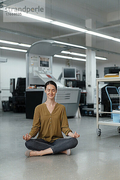 Geschäftsfrau praktiziert Yoga in Werkstatt