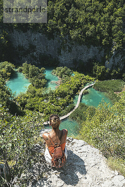 Wanderin bewundert die Landschaft des Nationalparks Plitvicer Seen vom Rand einer Klippe aus