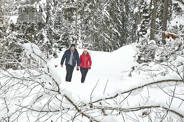Mann und Frau gehen im Winter auf Schnee