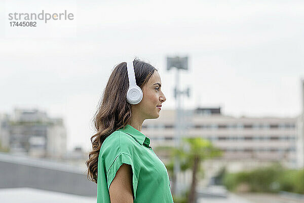Junge Frau hört Musik über kabellose Kopfhörer